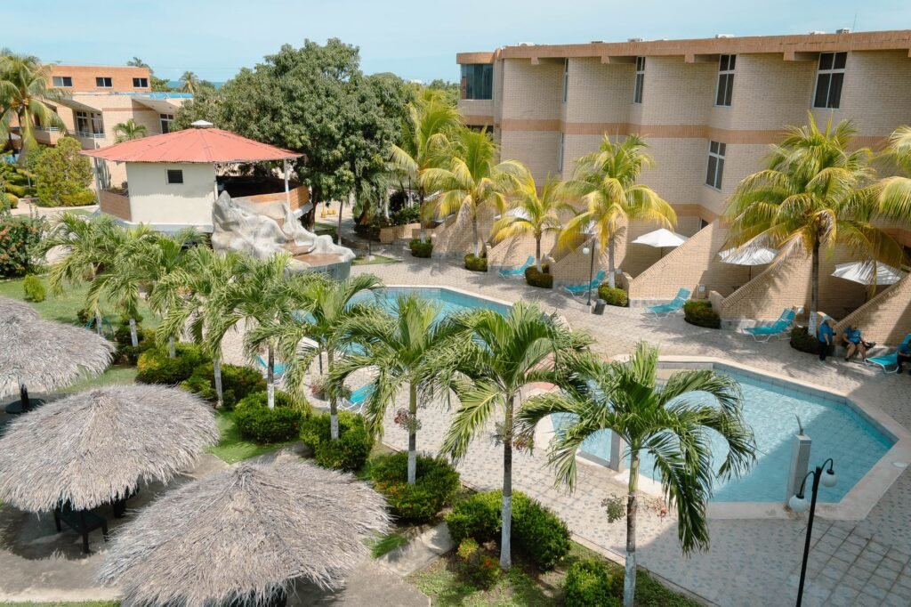 Discover a tranquil poolside oasis at a Venezuelan hotel with lush palms and inviting architecture.