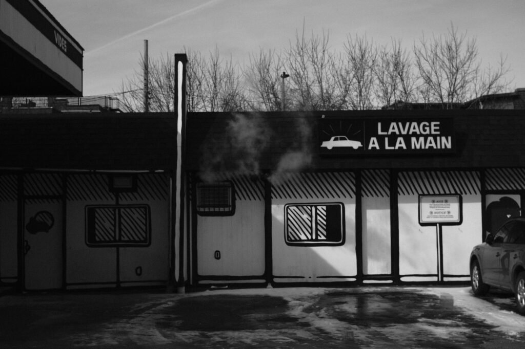 Black and white photo of a French hand car wash exterior in winter.
