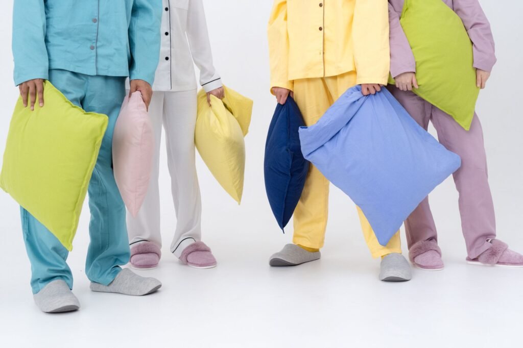 Group of people in colorful pajamas holding pillows, ready for a pillow fight.