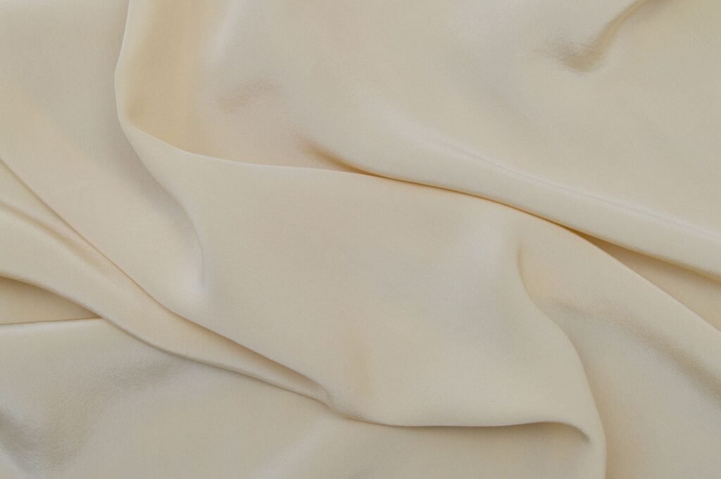 Detailed close-up image of beige fabric with soft, wavy texture.